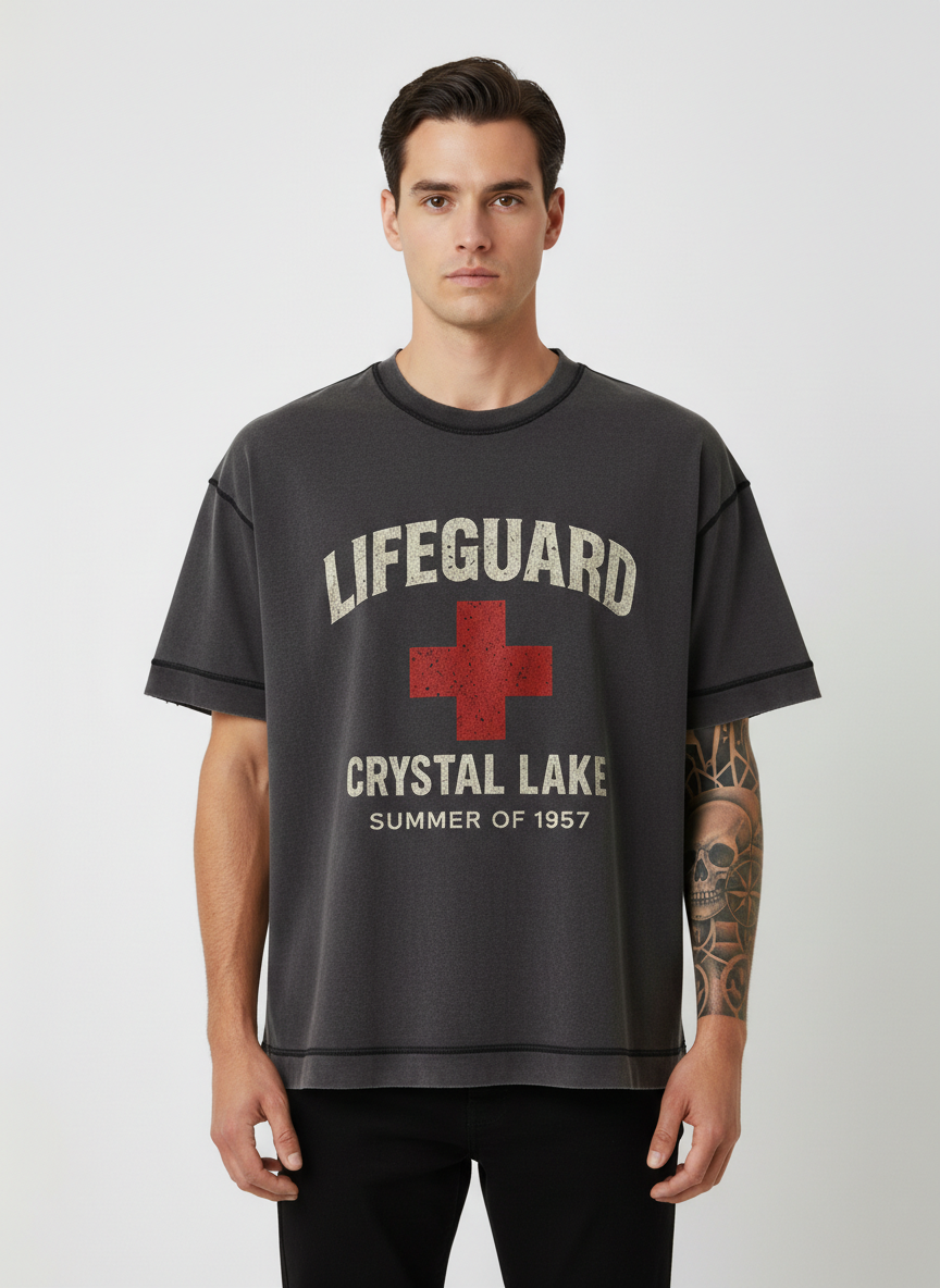 Screaming Saints Vintage Black Stitch Tee: Crystal Lake Lifeguard Summer of 1957 horror shirt with a distressed red cross graphic on a male model.