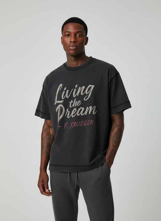 Screaming Saints Vintage Black Stitch Tee: Living the Dream F. Krueger horror shirt with a distressed claw-mark graphic on a male model.